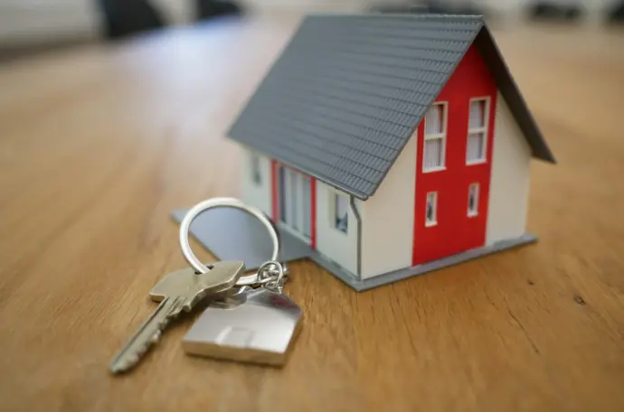 white and red wooden house miniature on brown table